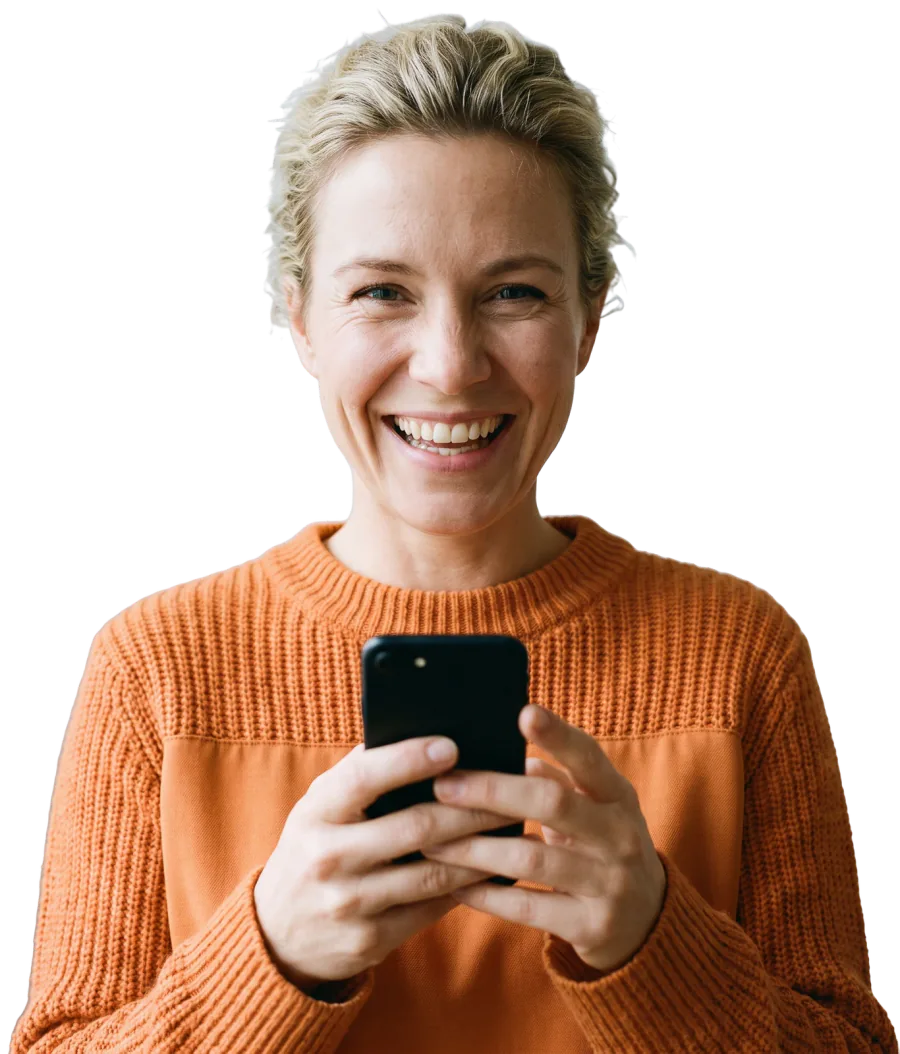 Smiling business owner in an orange sweater holding a phone